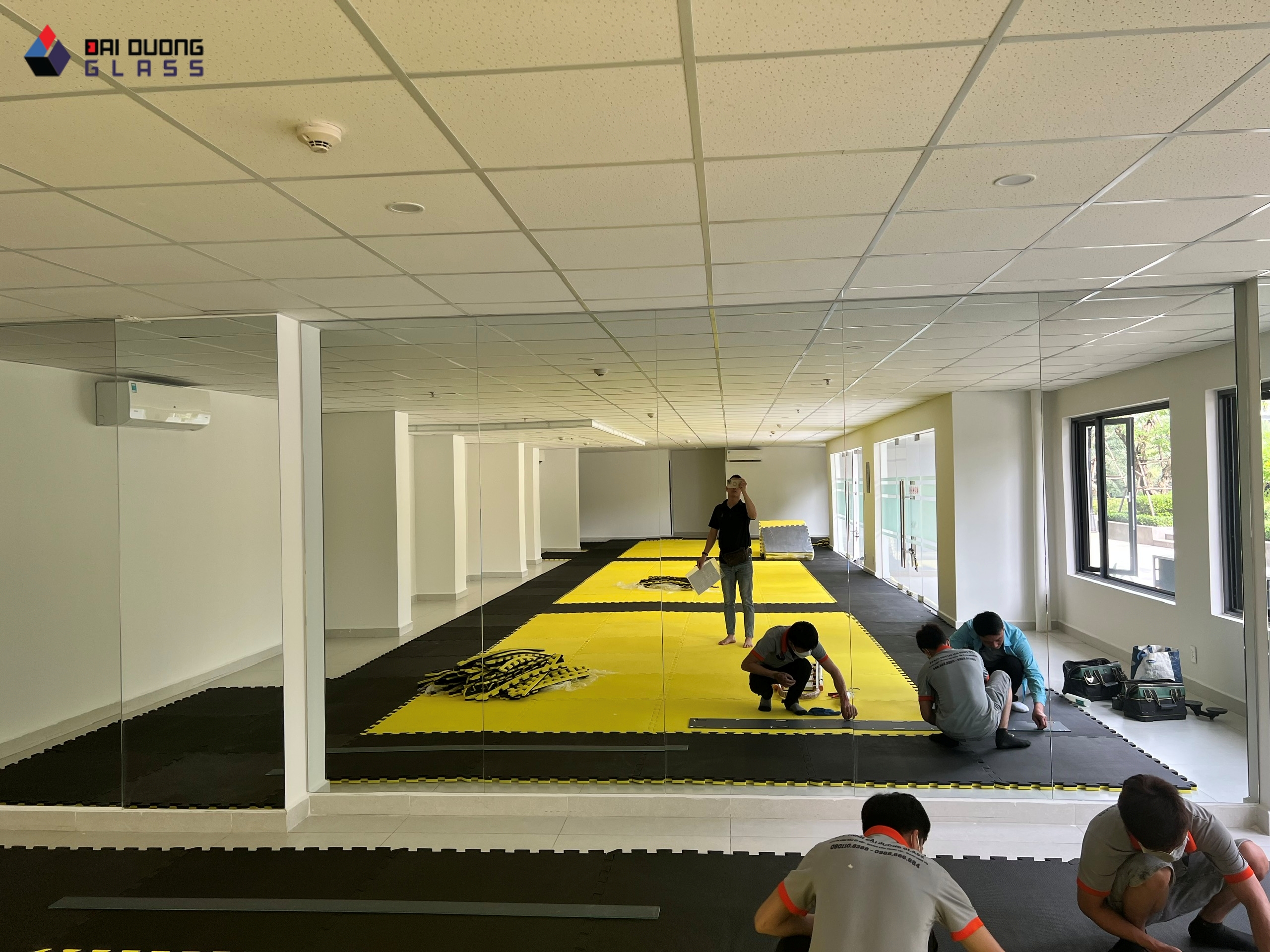 Đội thi công Đại Dương Glass trải thảm tập sau khi lắp gương dán tường cho phòng tập