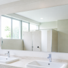 Gương nhà vệ sinh rộng phía trên hai bồn rửa trắng trong không gian sáng sạch
