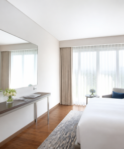 gương soi khách sạn trong phòng nghỉ hiện đại, giường trắng, sàn gỗ, cửa sổ rèm mỏng sáng