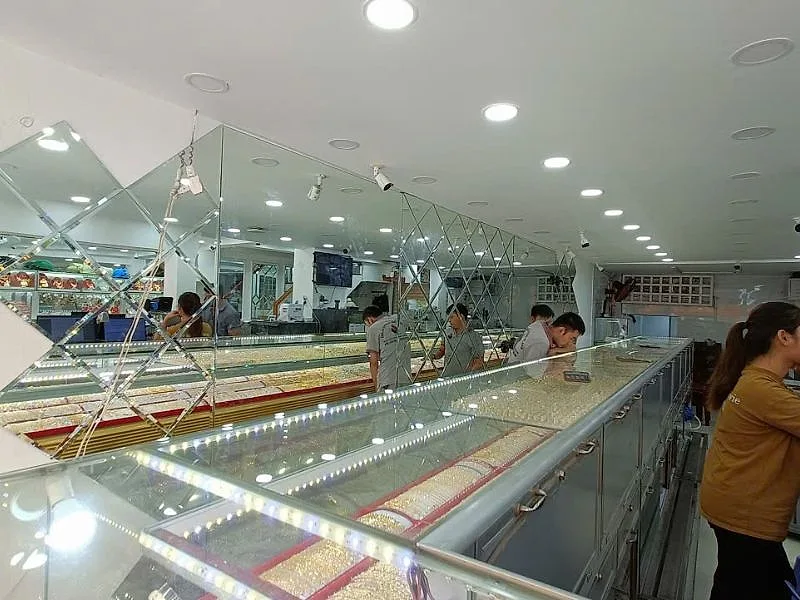 Xưởng Gương Bình Dương: Gương Cho Nhà Xưởng, Căn Hộ, Khách Sạn 1 Tường gương ghép hình thoi phía sau dãy tủ kính tiệm vàng