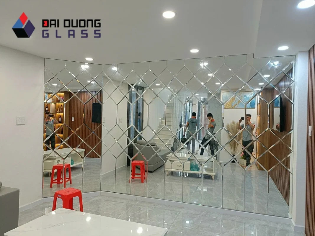 Xưởng Gương TP.HCM: Nhận Đơn Công Trình Và Số Lượng Lớn 21 Đội thợ đang lắp mảng gương ghép hình thoi khổ lớn trong một văn phòng, trên sàn còn thùng và vật tư thi công