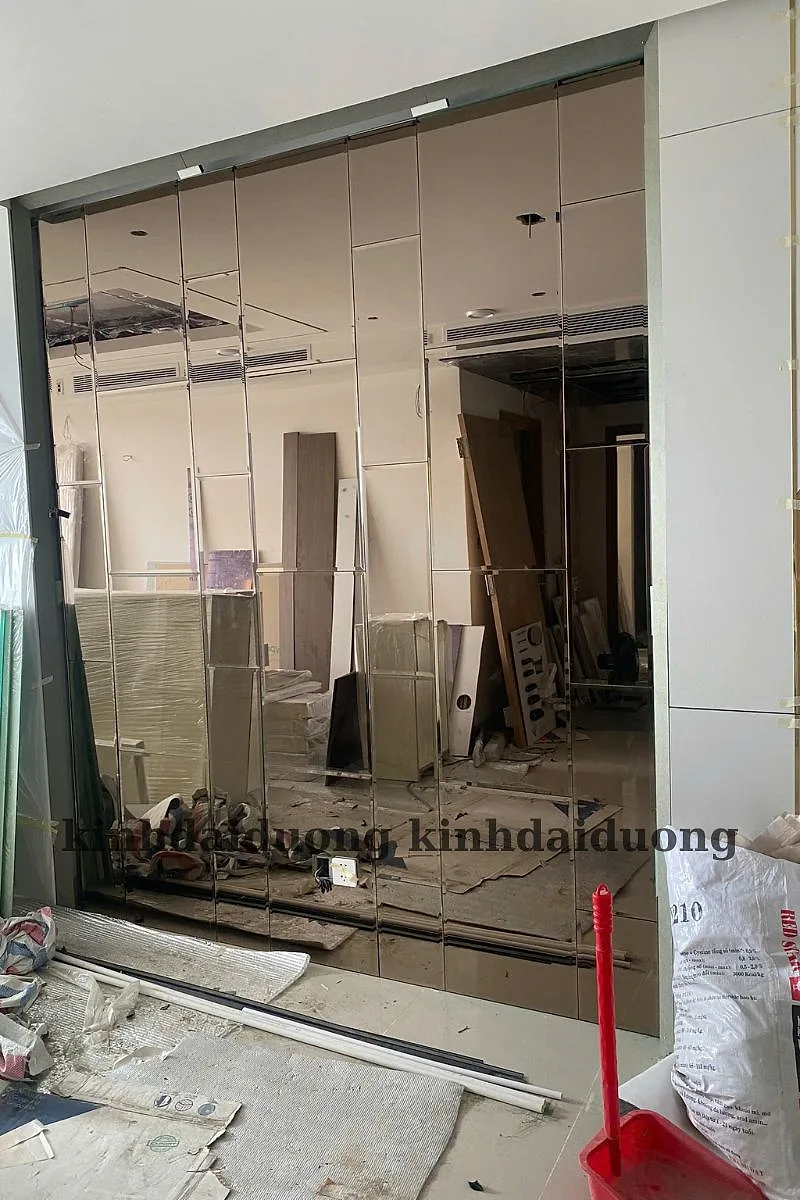 Thợ đang lắp gương ghép trang trí trong căn hộ đang hoàn thiện, vách còn bọc nilon