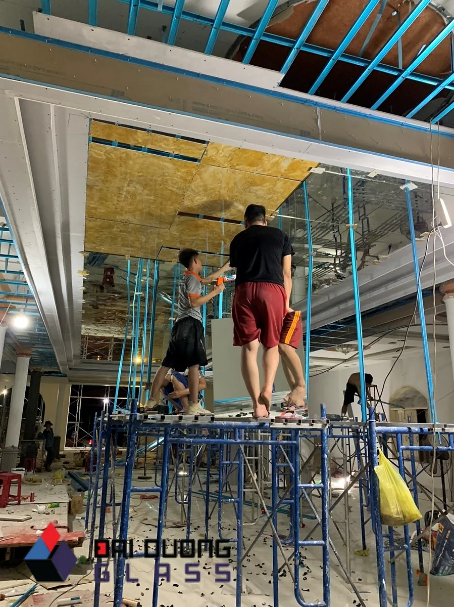 Xưởng Gương Vũng Tàu, Hồ Tràm: Gương Cho Công Trình Ven Biển 2 Nhiều thợ trên giàn giáo lắp trần gương khổ lớn trong không gian rộng