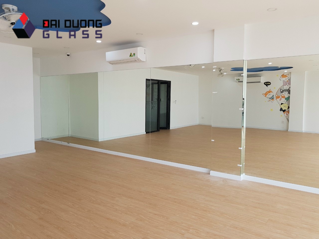 Mảng gương soi khổ lớn ốp kín một bức tường trong căn hộ, sàn gỗ, do Đại Dương Glass lắp
